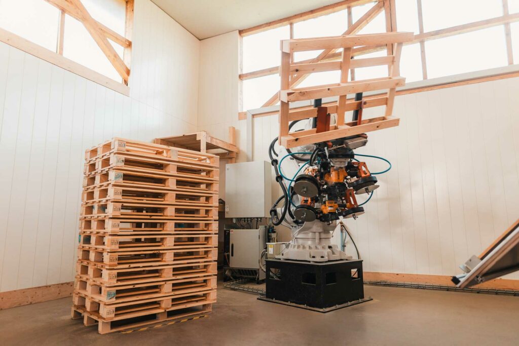 Roboter bei der Herstellung von Holzpaletten im Arbeitsschritt Ablegen der Palette